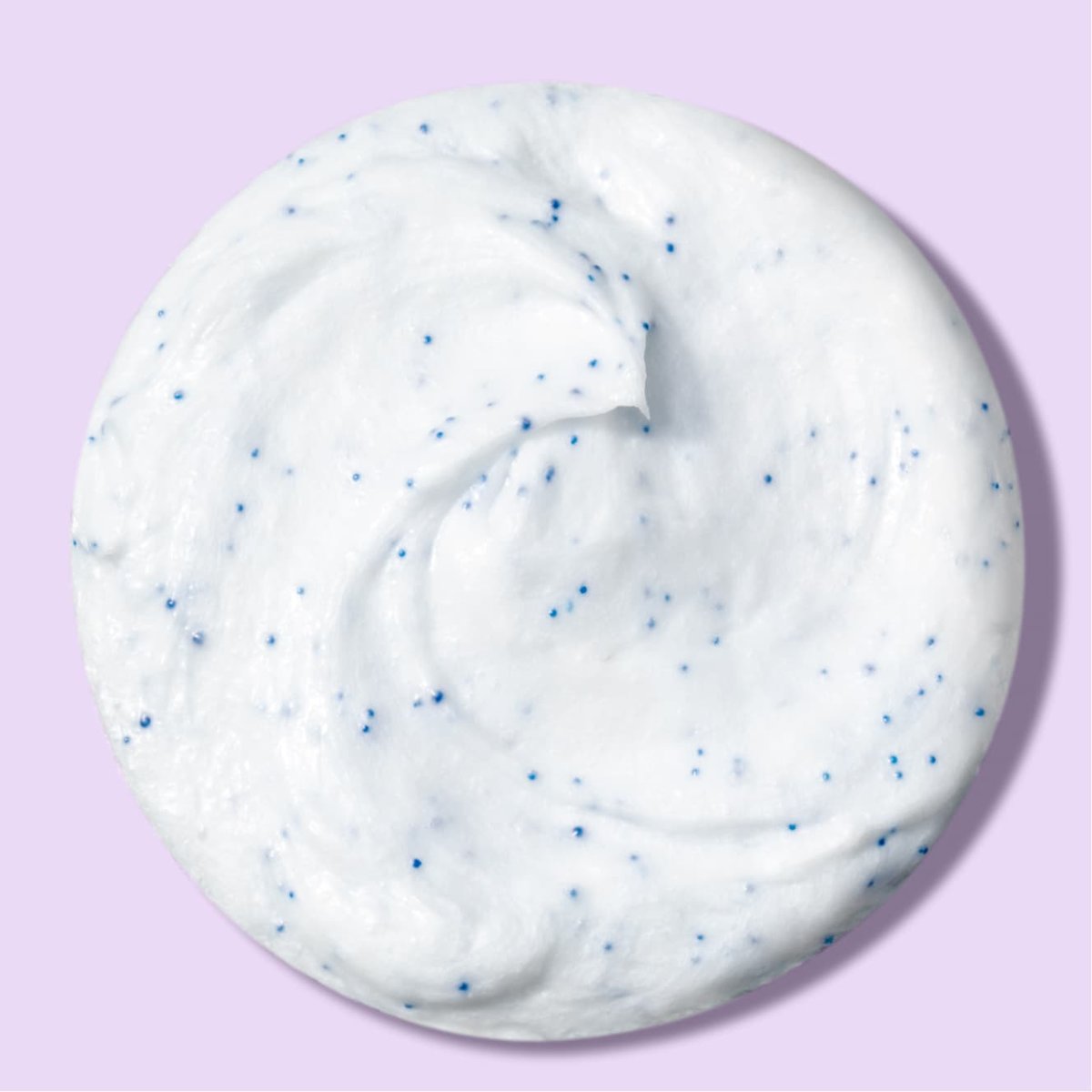 Whipped white blackhead eraser scrub with blue beads in front of a light purple background 