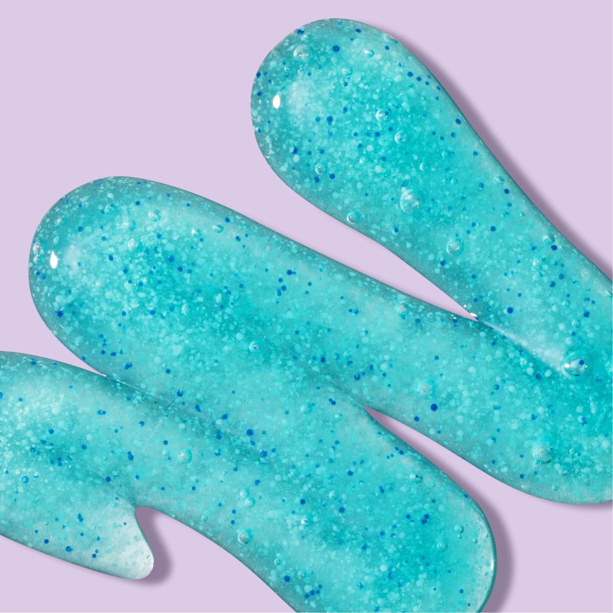 Turquoise deep action exfoliating scrub squiggle in front of light purple background