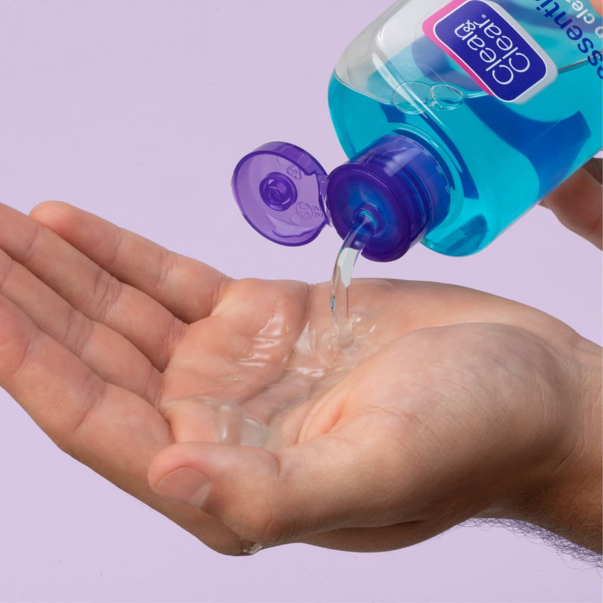 Clear deep cleaning toner for sensitive skin poured into hand from blue and purple Clean & Clear bottle in front of light purple background