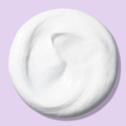 Circle blob of deep action cream cleanser in front of light purple background