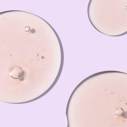 Circle blob of foaming cleanser in front of light purple background
